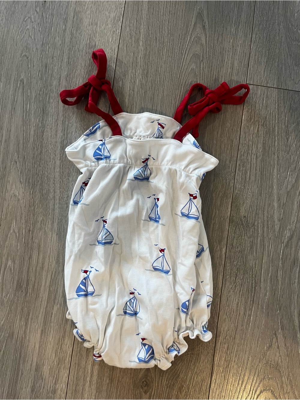 The Beaufort Bonnet Company White Romper with Blue Sailboats and Red Tie Straps